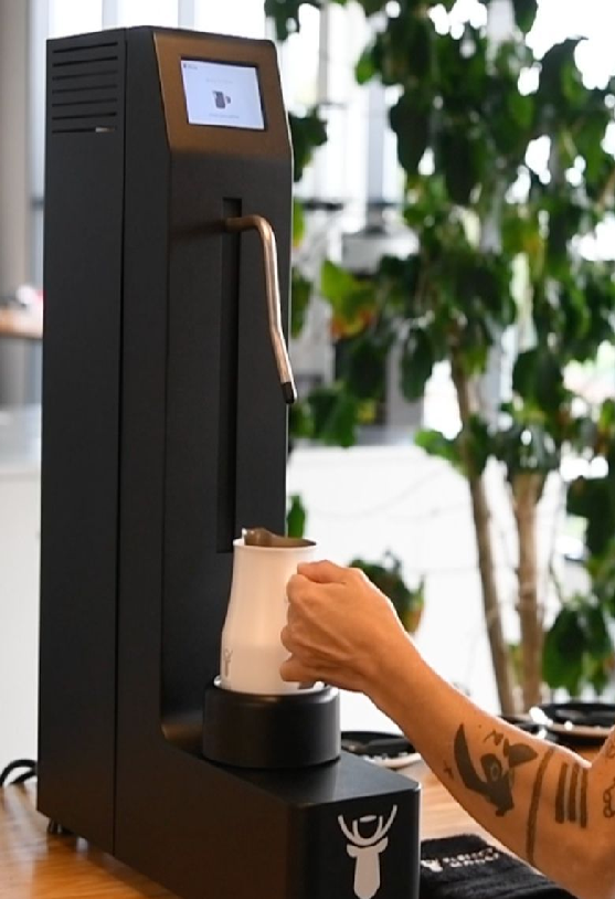 Perfect Moose automatic milk steamer dispensing milk into a pitcher
